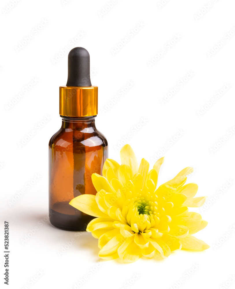 Essential oil of yellow chrysanthemum flower in a dark (brown) bottle with a pipette (bubble) on a white isolated background. Aromatherapy, spa. Oil for aroma lamps. Template for the design. Essential oil of yellow chrysanthemum flower in a dark (brown) bottle with a pipette (bubble) on a white isolated background. Aromatherapy, spa. Oil for aroma lamps. Template for the design.