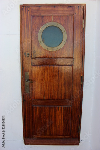 Belle porte de bateau en bois vernis photo