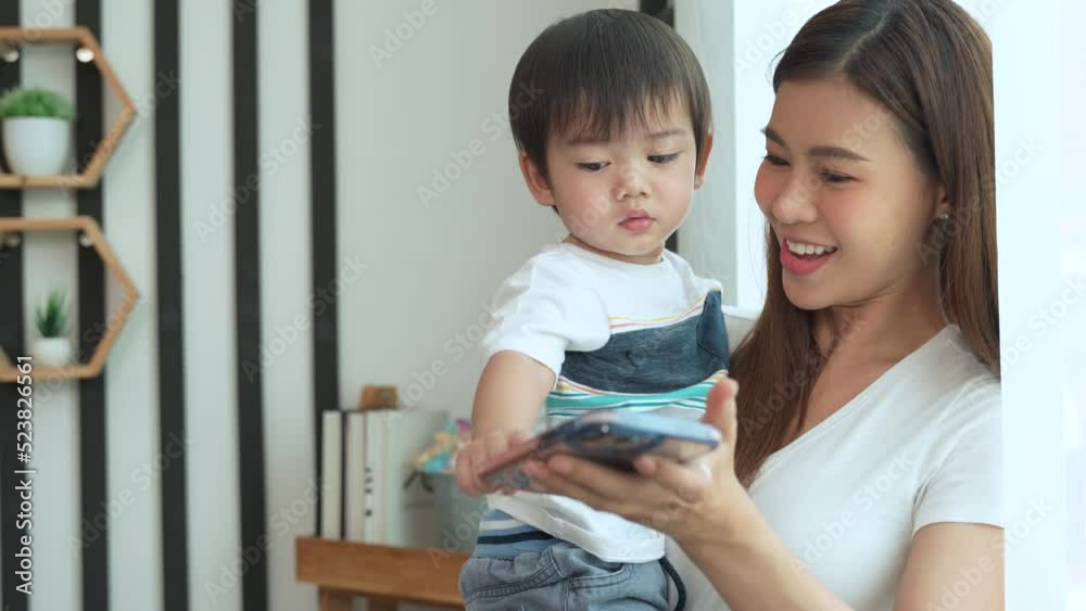 Asian young mother she is using her smartphone to open social media for