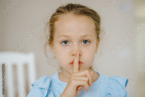 shh silence sign shown a little sad girl.Upset kid photo