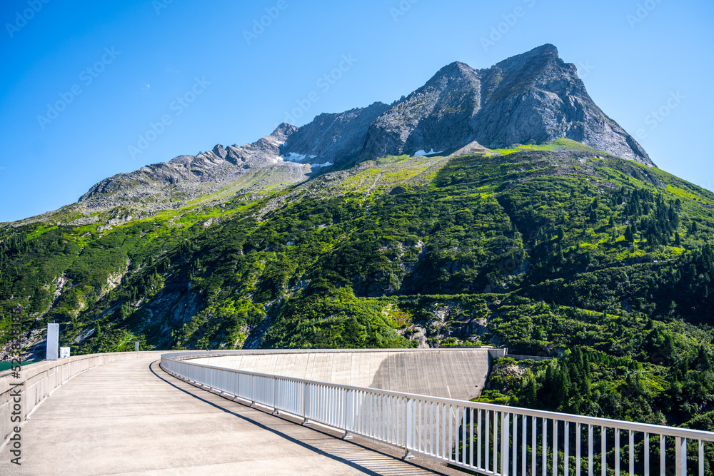 Huge concrete apline dam on sunny summer day