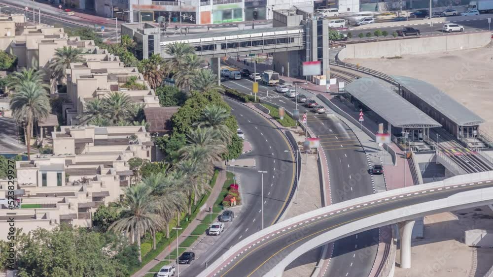 Tram station in Dubai Marina with footbridge aerial timelapse. Cars traffic on the intersection and overpass. View from above at morning Tram station in Dubai Marina with footbridge aerial timelapse. Cars traffic on the intersection and overpass. View from above at morning