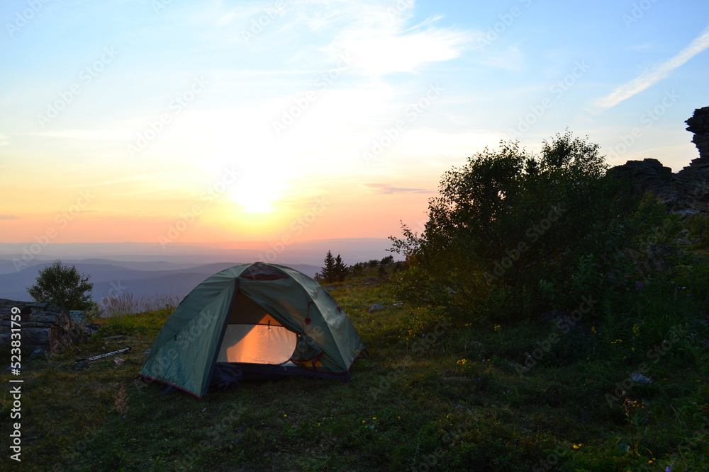 Tent on top of the mountain, evening sunset, warm summer day