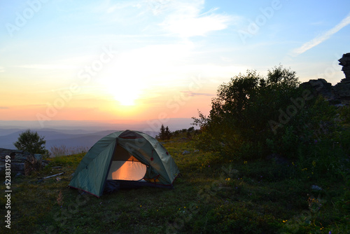 Tent on top of the mountain, evening sunset, warm summer day