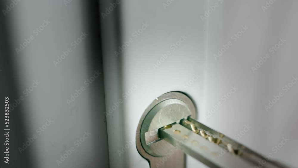 Slow uncertain insertion of a perforated key into the lock cylinder close-up Slow uncertain insertion of a perforated key into the lock cylinder close-up