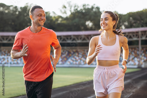 Couple running on the track at stadium