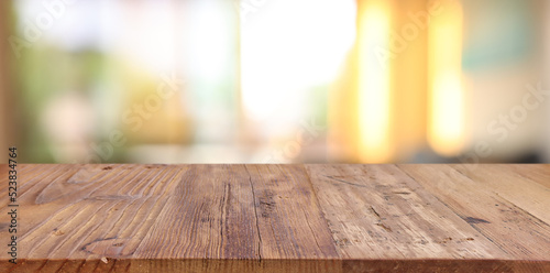 Wooden table and blurred window background, evening sunset light. Product display or mock up
