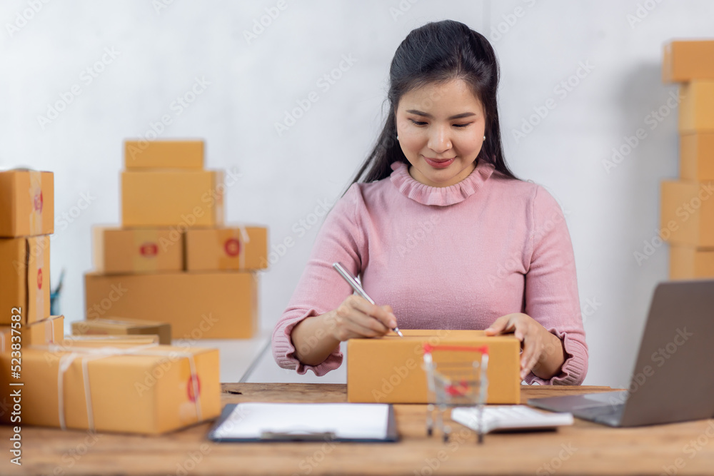 Portrait of young Asian woman working SME with a box at home the workplace.start-up small business owner, small business entrepreneur SME or freelance business online and delivery concept. Portrait of young Asian woman working SME with a box at home the workplace.start-up small business owner, small business entrepreneur SME or freelance business online and delivery concept.