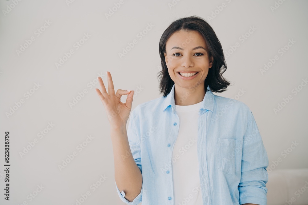 Happy mixed race lady shows ok sign. Concept of approval, success, positive emotion and confidence. Happy mixed race lady shows ok sign. Concept of approval, success, positive emotion and confidence.