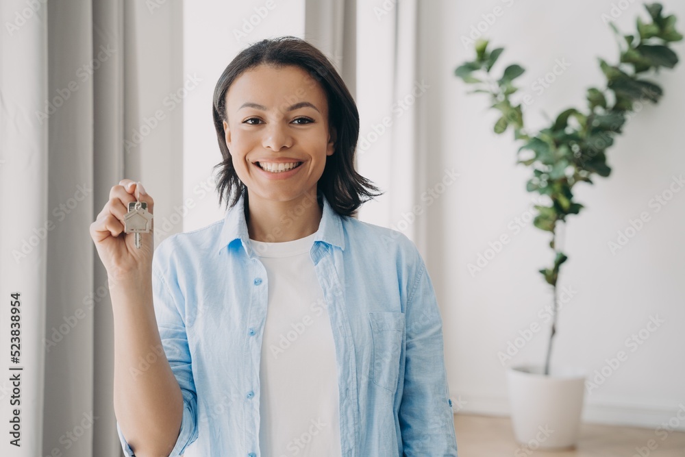 Gorgeous young lady is buying apartment and moving. Satisfied woman is holding house keychain. Gorgeous young lady is buying apartment and moving. Satisfied woman is holding house keychain.