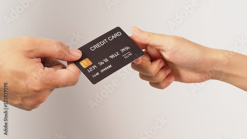 Two hands is send and receive black credit card on white background