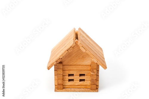Small wooden toy house. Background for the construction of housing from natural, environmentally friendly materials.