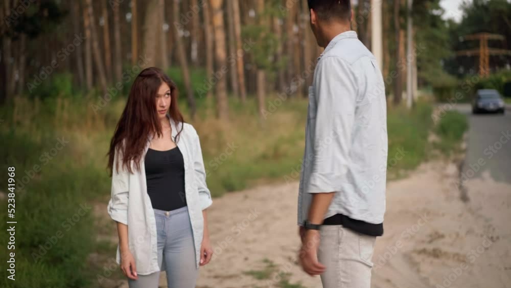 Nervous young man arguing with woman hitchhiking with Future banner. Portrait of dissatisfied Caucasian boyfriend tired of travelling with carefree girlfriend talking standing at forest on suburb road Nervous young man arguing with woman hitchhiking with Future banner. Portrait of dissatisfied Caucasian boyfriend tired of travelling with carefree girlfriend talking standing at forest on suburb road