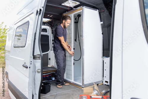 Man installing a shower room inside a camper van