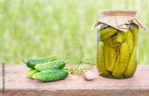 Ingredients for preservation and a jar of pickled cucumbers
