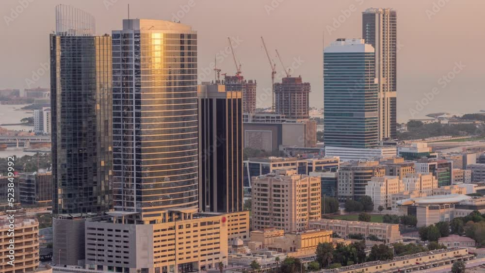 Office buildings in Dubai Internet City and Media City district aerial night to day transition timelapse. Traffic on junction and skyscrapers with sunrise and sun reflected from glass Office buildings in Dubai Internet City and Media City district aerial night to day transition timelapse. Traffic on junction and skyscrapers with sunrise and sun reflected from glass