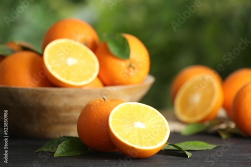 Fresh ripe oranges on wooden table against blurred background. Space for text