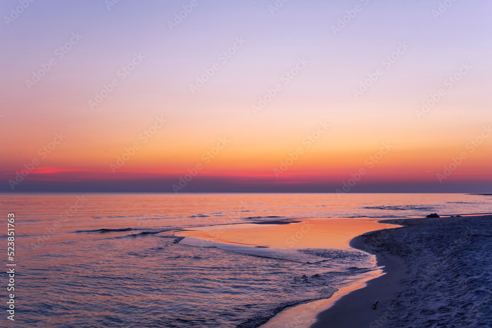 Empty Baltic Sea beach landscape Orange horizon above the water. Scenic seascape  with sunrise sky and calm water.