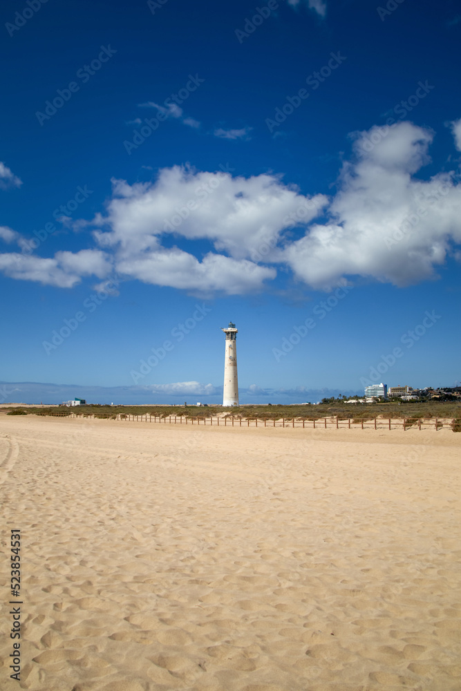 the Jandia lighthouse behind the wide, fine sandy beach in southern Fuerteventura, Canary Islands, Spain