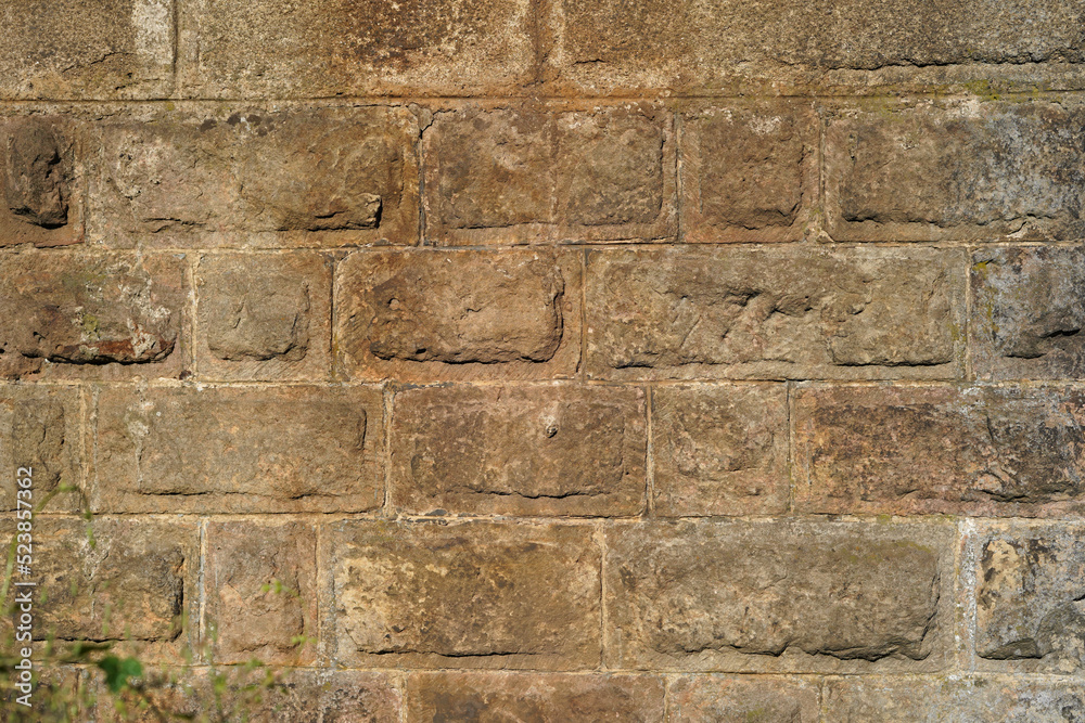 Large stone blocks forming a wall. They have an ocher color. Solid image suitable for background.