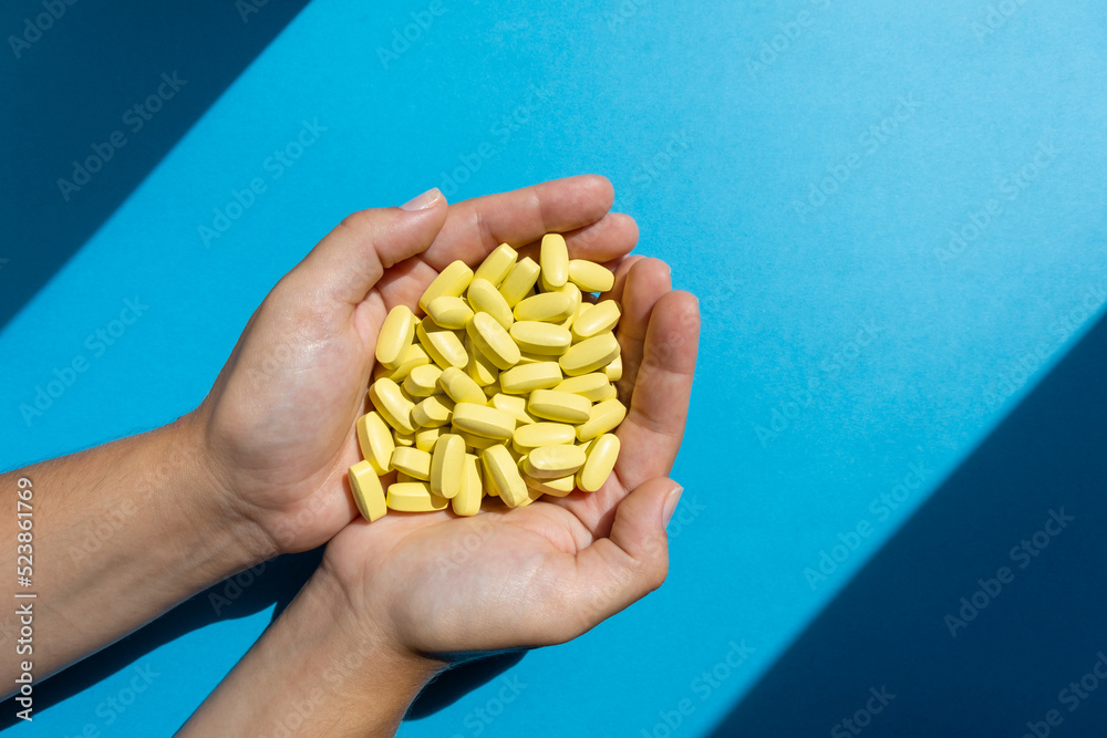 Obraz premium Hands of doctor holding a lot of medicine vitamin capsules or pills. Healthcare or medical concept.