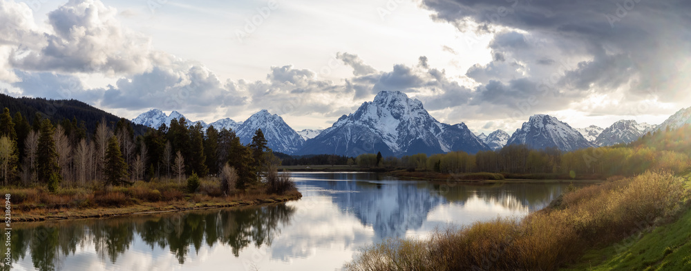 River surrounded by Trees and Mountains in American Landscape. Snake River, Oxbow Bend. Spring Season. Grand Teton National Park. Wyoming, United States. Nature Background Panorama. Sunset