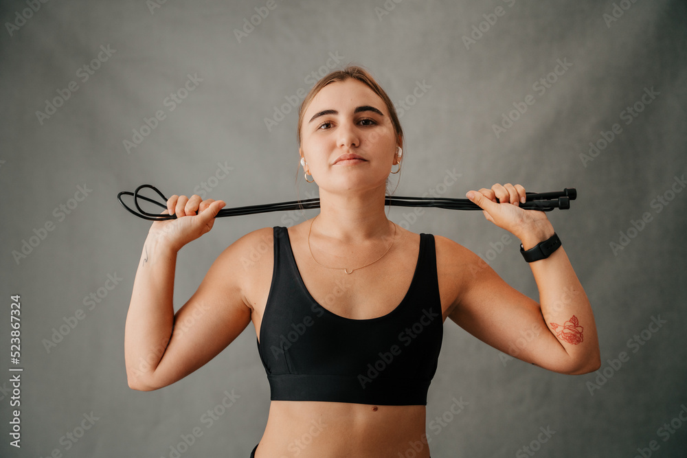 Close up focused Caucasian female close up skipping rope around her neck  wearing her sports bra and ear pods Stock Photo