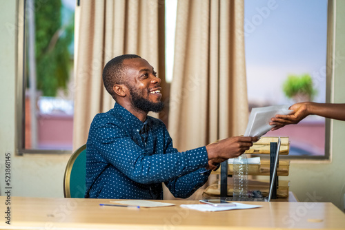 Wallpaper Mural Happy African businessman in office handing over files or documents - concept on Black people and entrepreneurship Torontodigital.ca