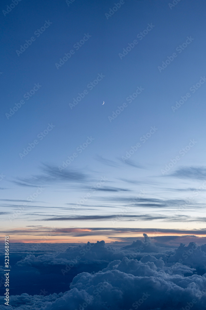 Moon above the clouds at dusk - Portrait 