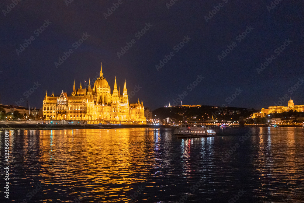 Országház, Hungarian Parliament Building, seen from the Danube river at night in Budapest - Wide side on 