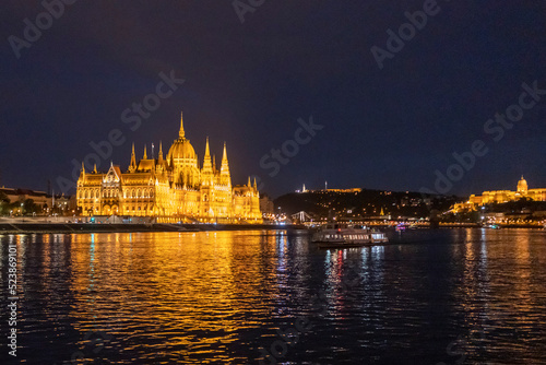 Orsz  gh  z  Hungarian Parliament Building  seen from the Danube river at night in Budapest - Wide side on 