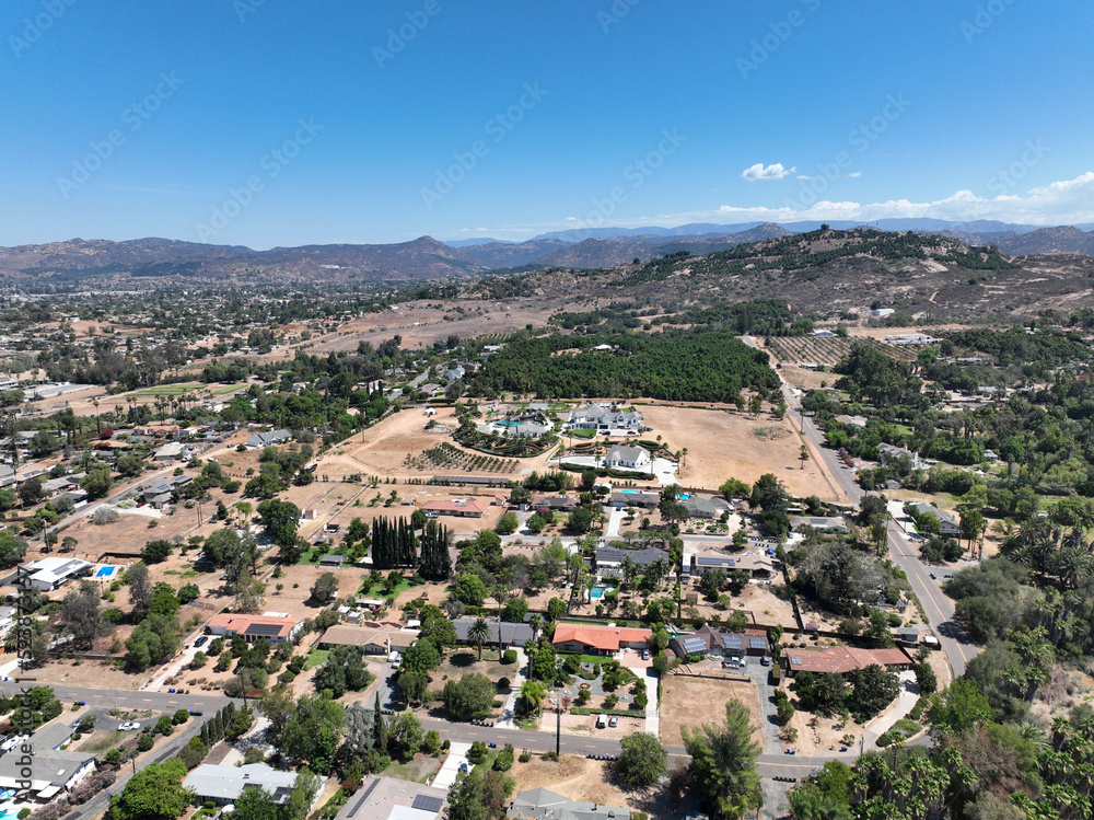 Aerial view of dry valley and land with houses and barn in Escondido, San Diego, California
