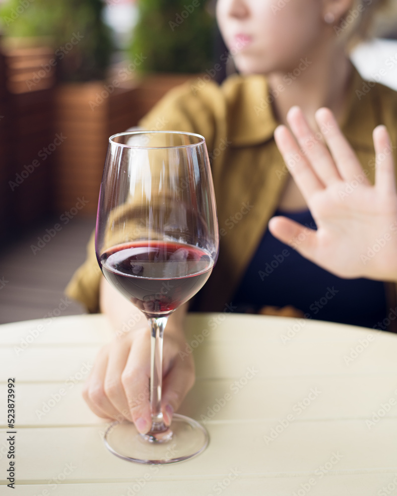 girl refuses to drink wine, non-alcoholic concept, selective focus, blur girl refuses to drink wine, non-alcoholic concept, selective focus, blur