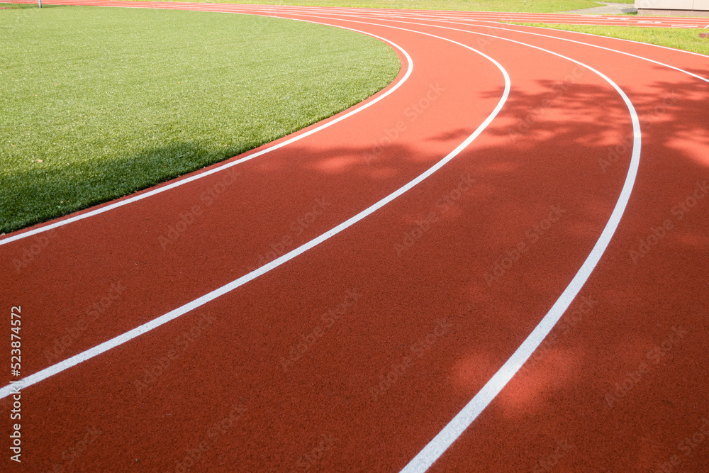 School sports stadium with red artificial rubber ground running tracks white lines on it School sports stadium with red artificial rubber ground running tracks white lines on it