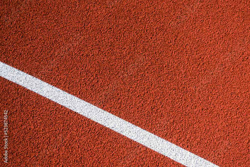 Fototapeta Naklejka Na Ścianę i Meble -  Colorful sports court background. Top view to red field rubber ground with one white line outdoors