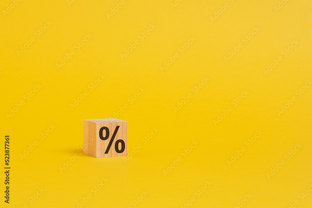 percent sign on wooden cubes against gray background with copy space. concept of sale and discount, yellow background