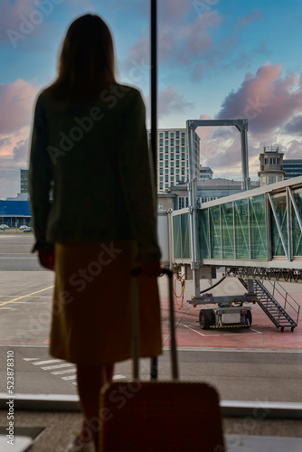 Woman with luggage waiting for the flight in airport. photo