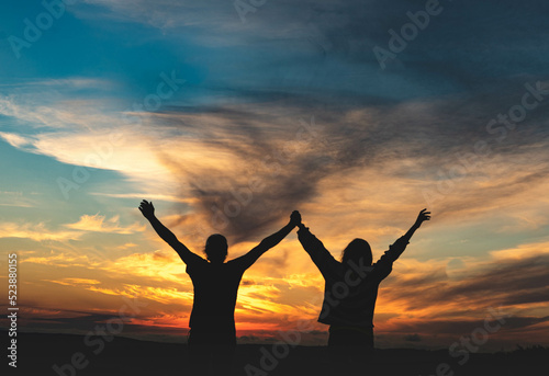 couple with arms raised
