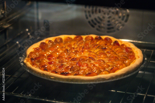 Mirabelle plum tart baked in a backing pan in the oven.