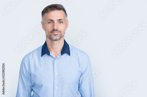 positive mature businessman in office shirt on grey background © be free