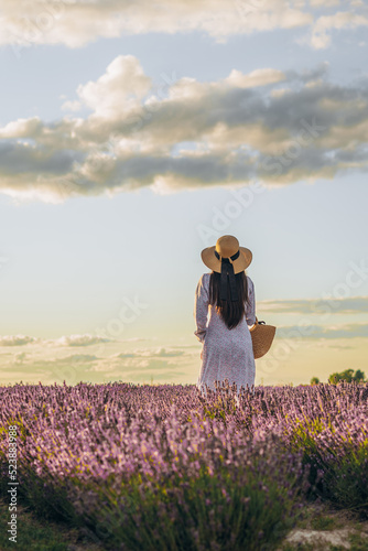 girl stands with her back against the background of a lavender field