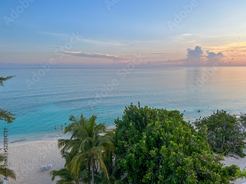 An aerial view of Cemetery Beach on Seven Mile Beach in Grand Cayman Island with a beautiful sunset.