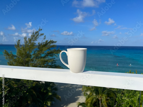 A coffee cup with an aerial view of Cemetery Beach on Seven Mile Beach in Grand Cayman Island on a beautiful sunny day.