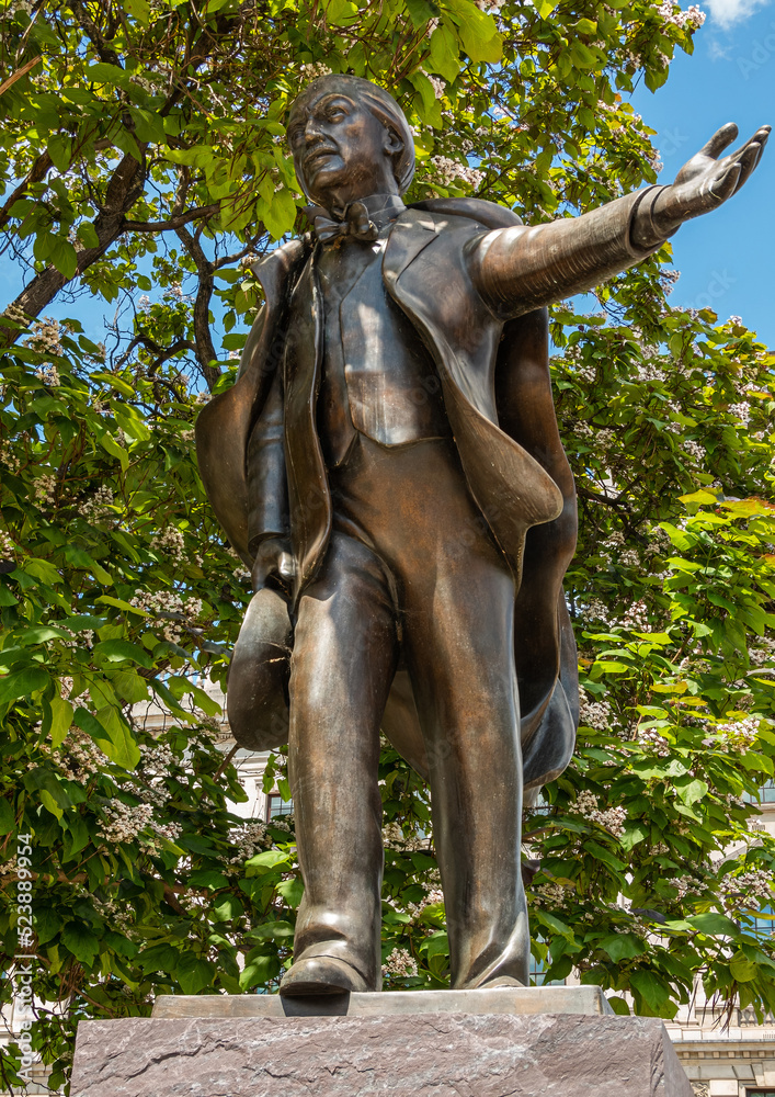 London, UK - July 4, 2022: Parliament Square Gardens. Bronze statue of David Lloyd George closeup under green foliage.