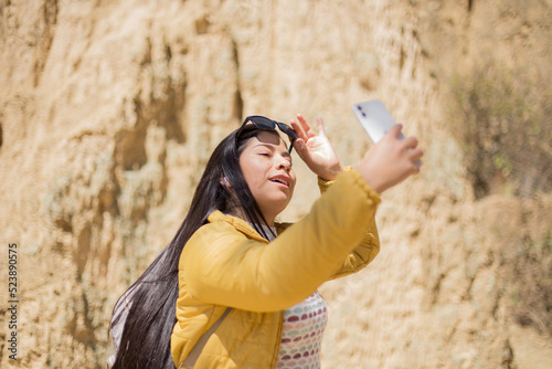 Mujer turista tomando selfies con su teléfono en un cañon. Concepto de turismo, viajes, vacaciones photo