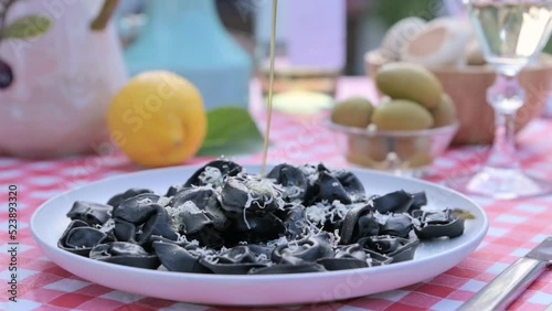 Outdoor lunch. Black tortellini and served table. Italian cuisine for a summer dinner in the garden. High quality FullHD footage photo