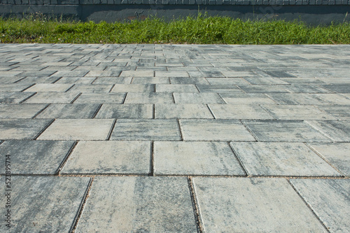 paving slabs, in the photo sidewalk decorative gray tiles close-up