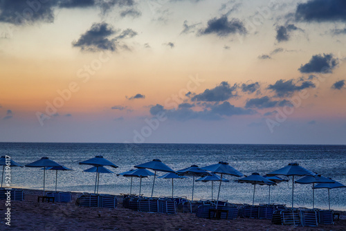 Afandou sea beach with sunshades in Rhodes at sunrise of sunny summer day, Greece, Europe.