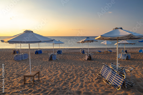 Afandou sea beach with sunshades in Rhodes at sunrise of sunny summer day, Greece, Europe.