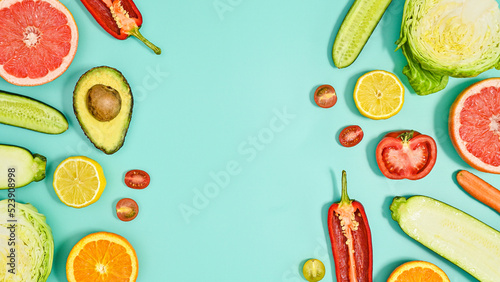 Copy space background with sliced fresh fruits and vegetables on cyan theme. Flat lay HEalthy lifestyle